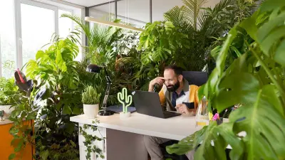 Two associates are playing on a football table with a Bosch Rexroth APAS assistance robot.
